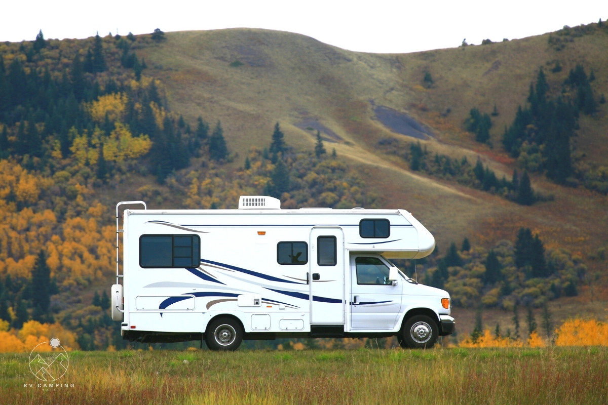 class c motorhome driving on road through fall foliage in mountains