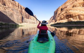 Adventurous woman on a kayak paddling in colorado river