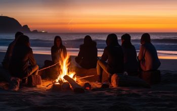 Photo a group of people sit around a campfire on the beach at sunset.
