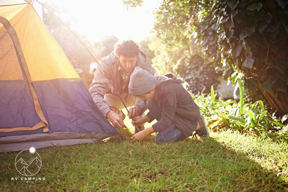 Father child and preparing tent for camping outdoor in nature on vacation while bonding in summer sunset dad boy and setting up camp learning and getting campsite ready in forest for travel