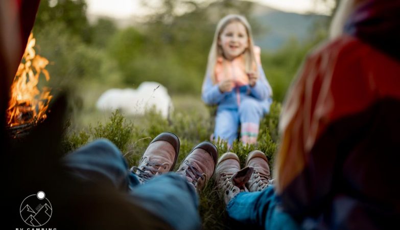 Photo cute little girl tell some story to her parents that sit in camping tent